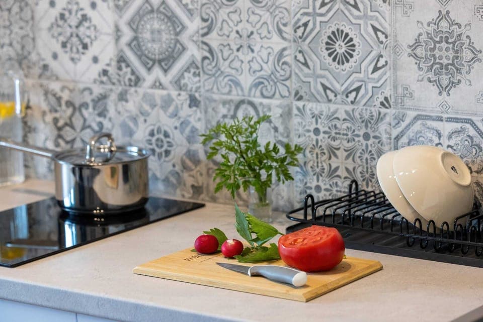 A sleek countertop with modern appliances, fresh fruit, and decorative elements, perfect for preparing meals.