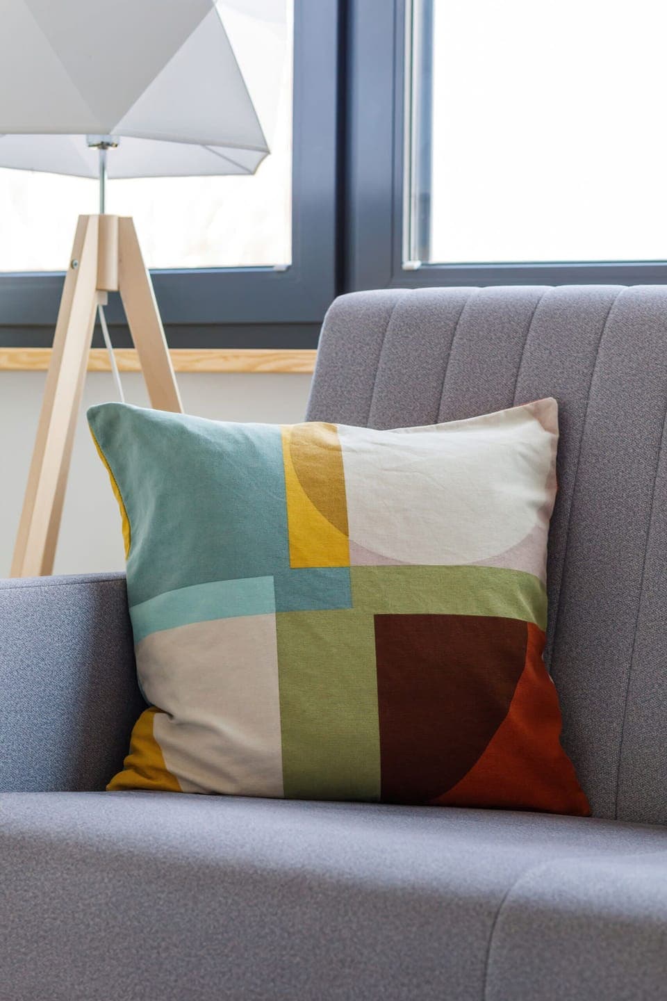 A close-up of a gray sofa adorned with colorful, patterned cushions, adding a pop of color to the room.
