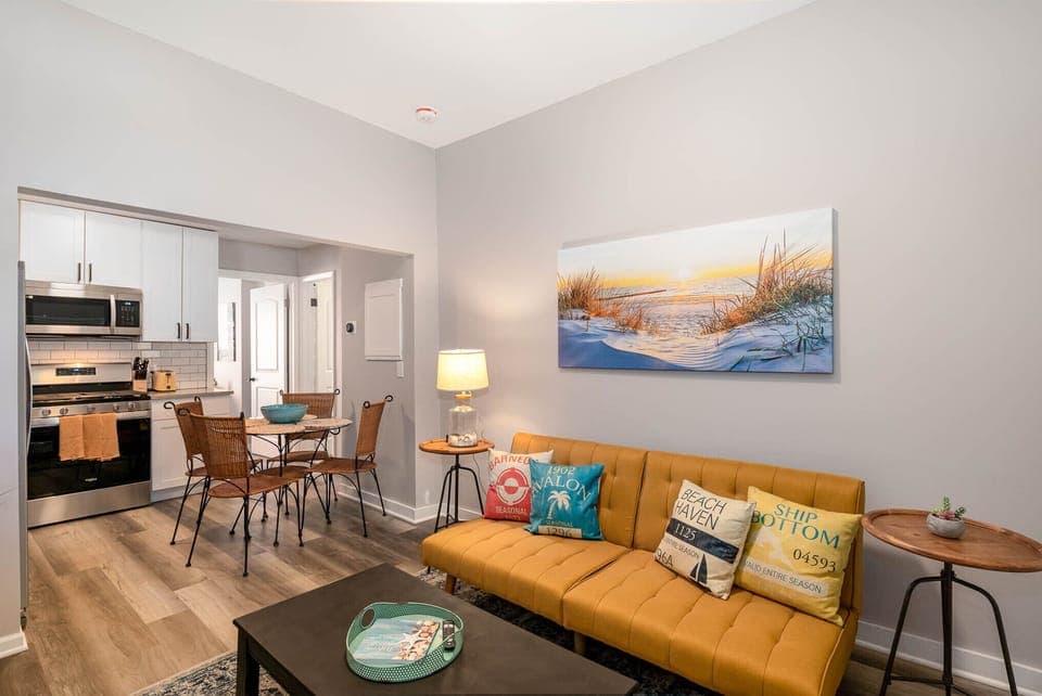 Open living room and kitchen area with futon couch and 50" smart TV