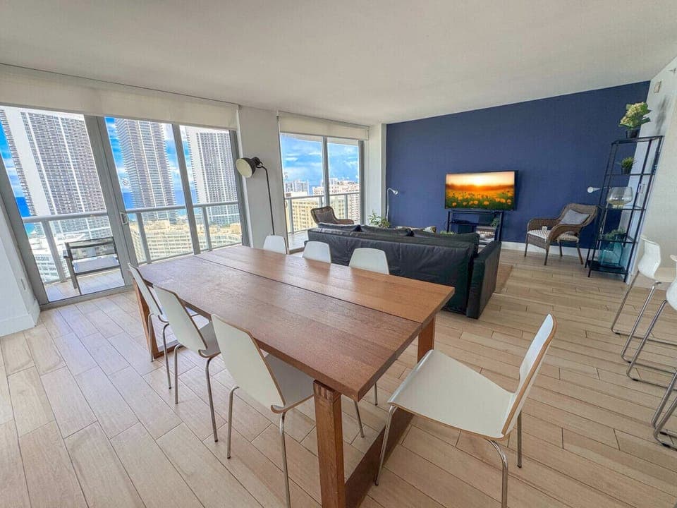 Bright living room with balcony access and city views.