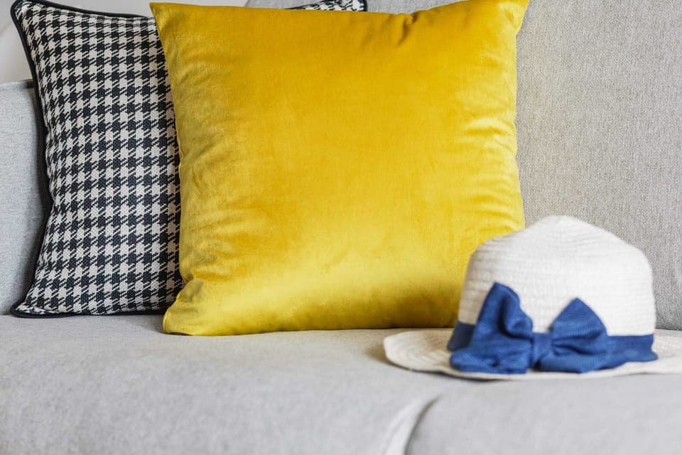 A closer view of the living room, showcasing decorative pillows and throws in vibrant yellow tones for a lively touch.