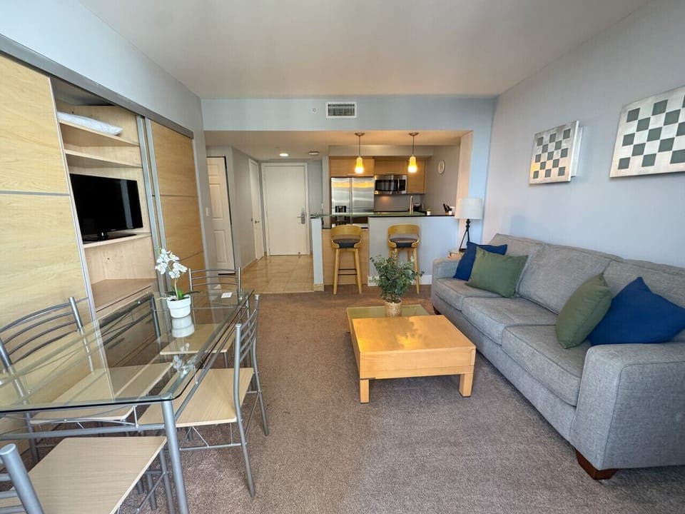 Bright living room with balcony access and city views.