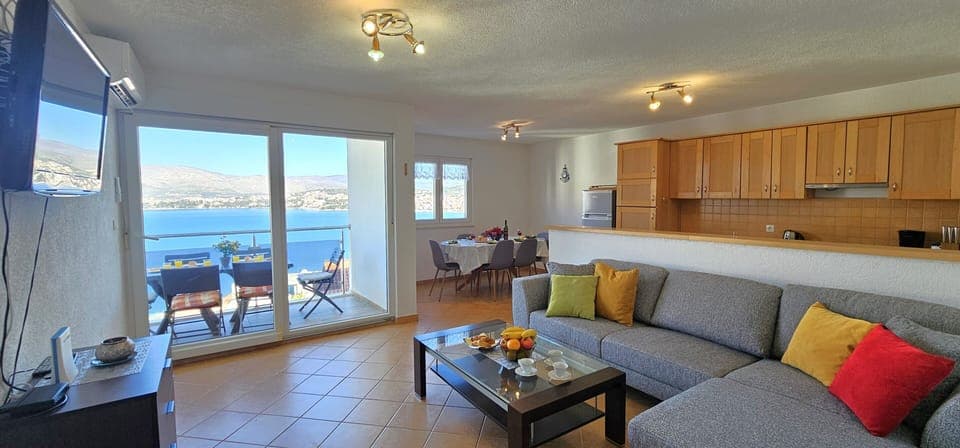 Open plan living/dining and kitchen area opening into sea view terrace