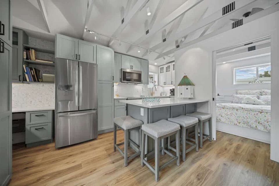 Modern updated kitchen featuring sleek stainless steel appliances, a spacious layout, and a stylish kitchen island with barstool dining—perfect for meals and gathering.
