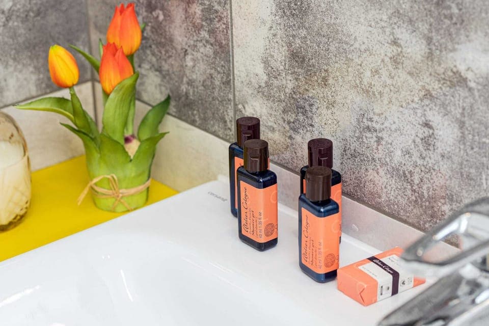 A close-up of the sink area featuring bright yellow decor and luxurious toiletries.