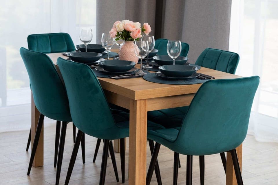 A beautifully arranged dining table with blue chairs, ready for a meal.