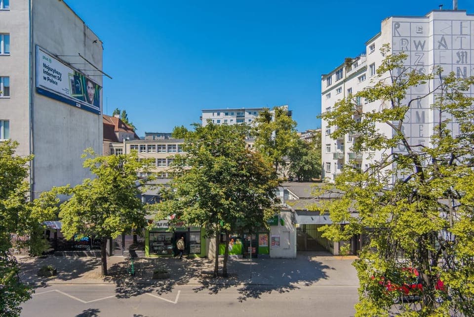 A scenic view of the surrounding area, featuring greenery and modern buildings in a tranquil neighborhood.





