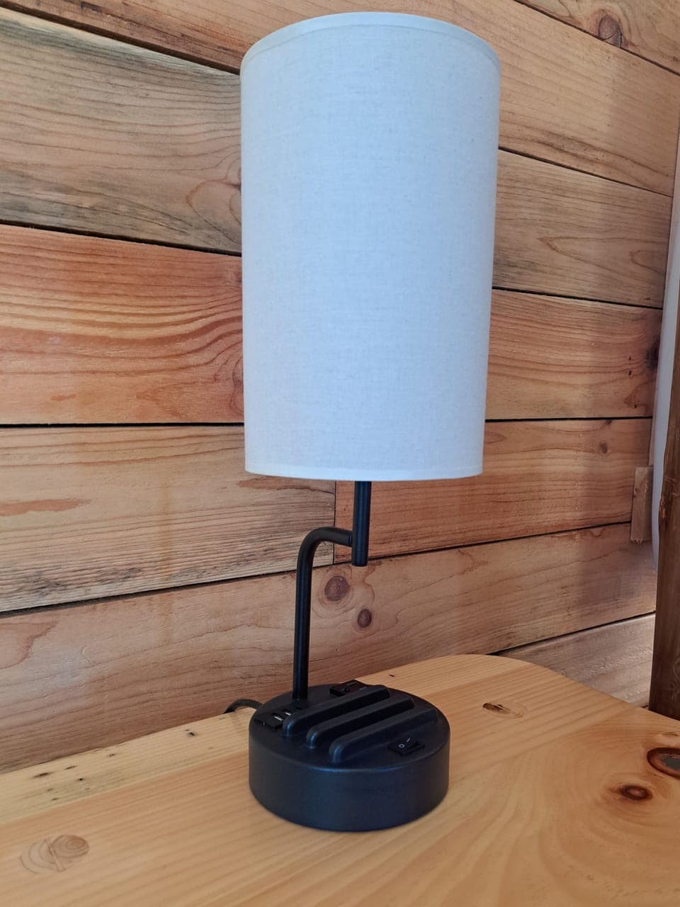 The master has two table lamps with charging ports and phone stands.