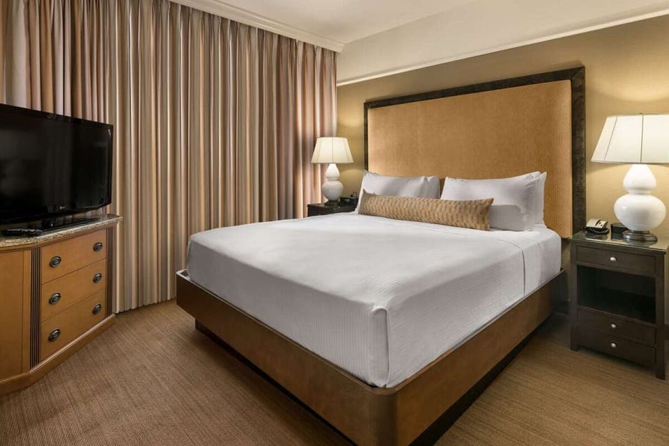 Unwind in a plush king bed with warm lighting.