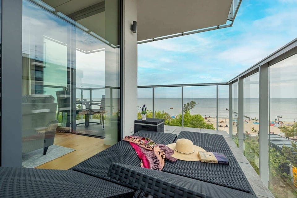A stunning balcony with lounge chairs and a panoramic view of the surrounding area.

