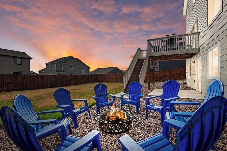 8 chairs around a wood burning campfire pit with marsh mellow sticks