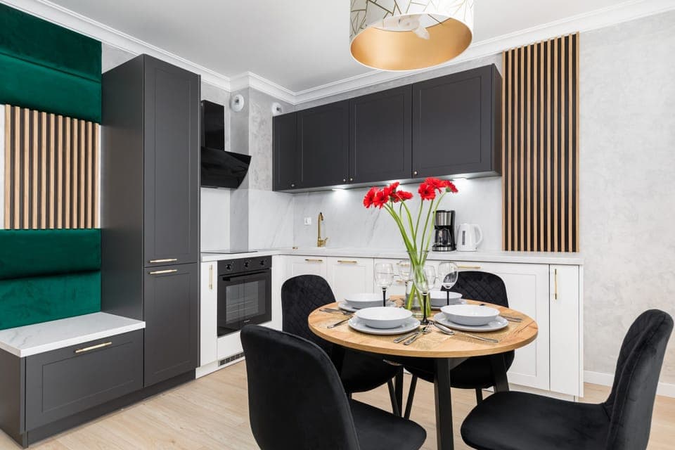 Open-plan kitchen and dining area with a sleek design and a dining table set for four.

