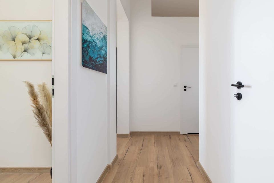 Minimalist hallway with neutral decor and stylish details, leading to the rooms.

