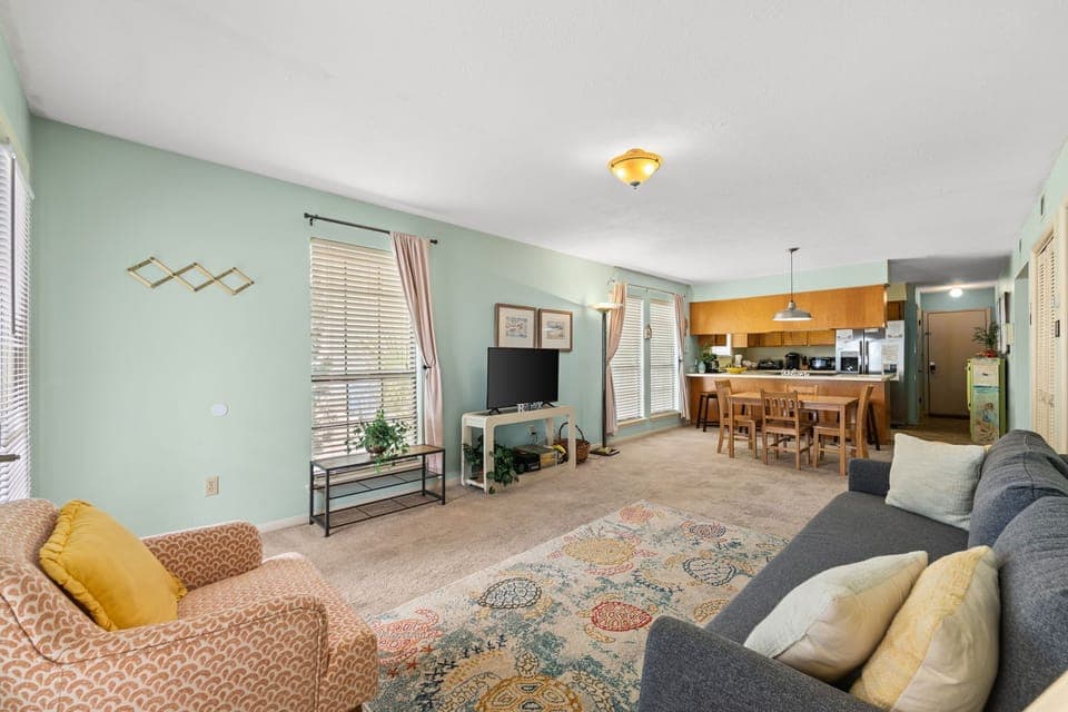Unwind in your spacious open-concept living space with soft mint walls and cozy seating areas.