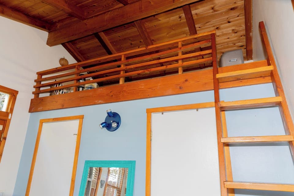 Stairs up to loft sleeping area with dedicated a/c. Doors to closet and bath