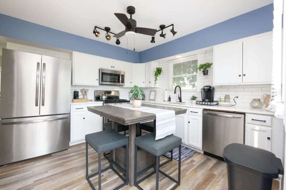 Stylish kitchen w/ stainless fridge, island seating & blue accent walls