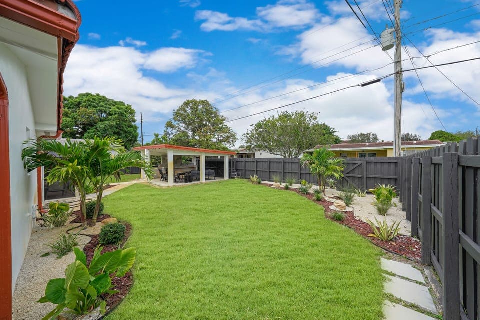 Surrounded by lush greenery and beautiful landscaping, the backyard provides a sense of serenity and privacy as it is fully fenced. 