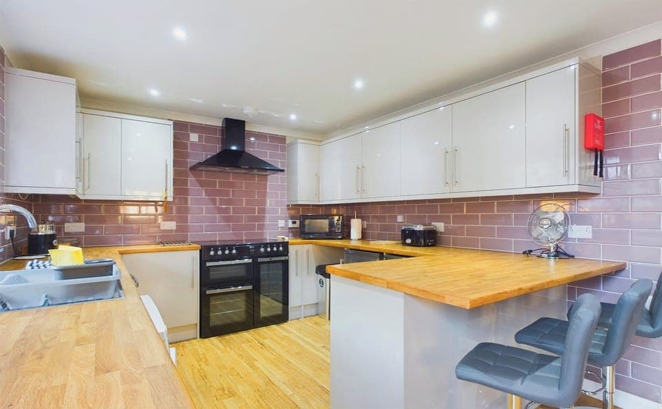 A bright, modern kitchen fully equipped for self-catering, featuring a breakfast bar for casual holiday meals.