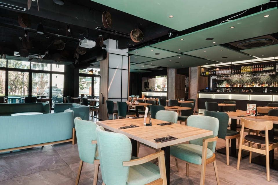 A stylish dining area with cozy seating and modern decor, perfect for socializing or enjoying meals.