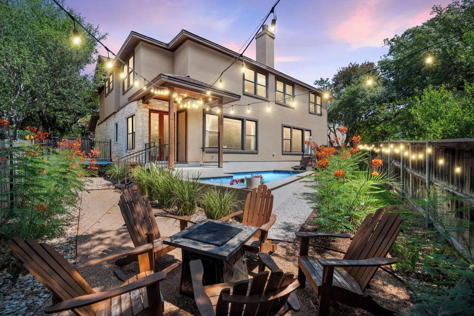 Cozy backyard patio with a fire pit under string lights.