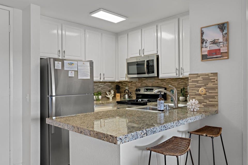 Two  bar stools offer extra seating by the kitchen island, ideal for younger children or enjoying a quick bite.