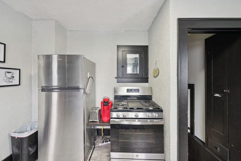 Coffee-making supplies, full-size refrigerator, and cooking stove.