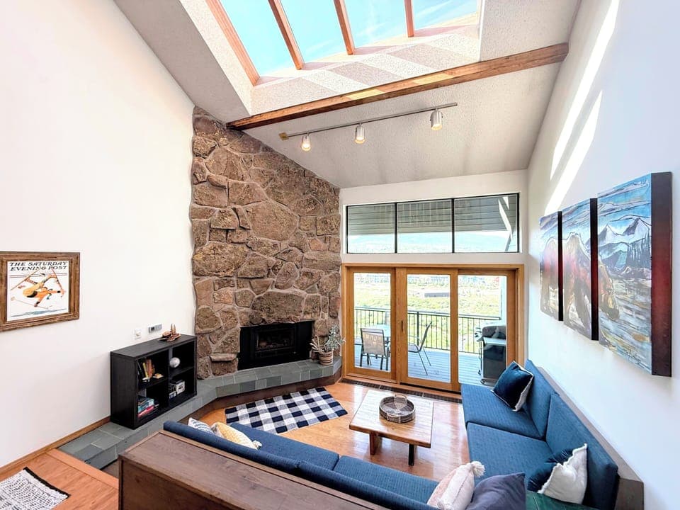 Living room with gas fireplace and deck with a propane grill.