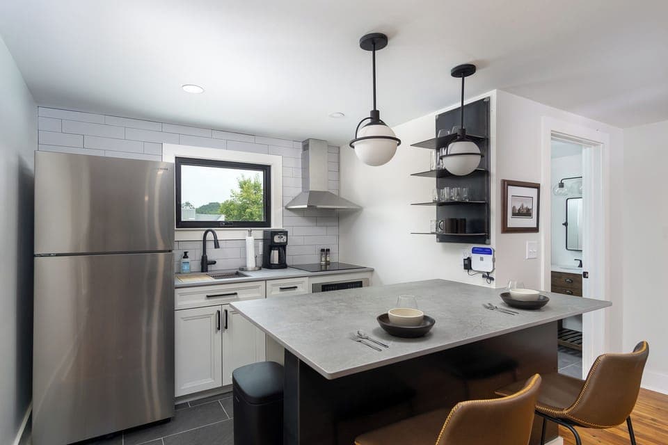 Open-concept kitchen with stainless steel appliances and breakfast bar seating for 2. Please note: The standard drip-style coffeemaker has been replaced with a Keurig.