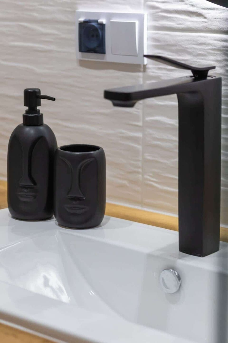 A modern bathroom with sleek black fixtures and minimalist decor, ensuring a stylish and functional space.
