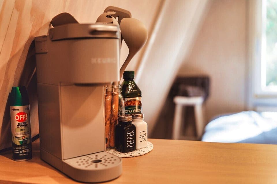 The A-frame comes with a Keurig machine, mini fridge, countertop burners, and the dining basics.