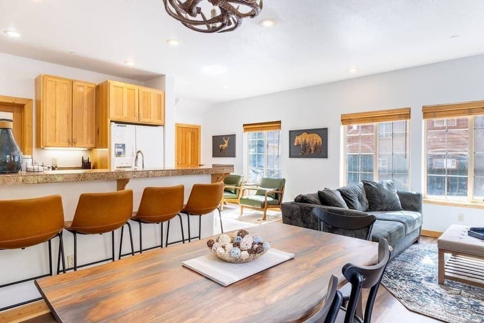 The open living room/dining area/kitchen is a space filled with natural light, an ideal space for socializing or relaxing with your group.