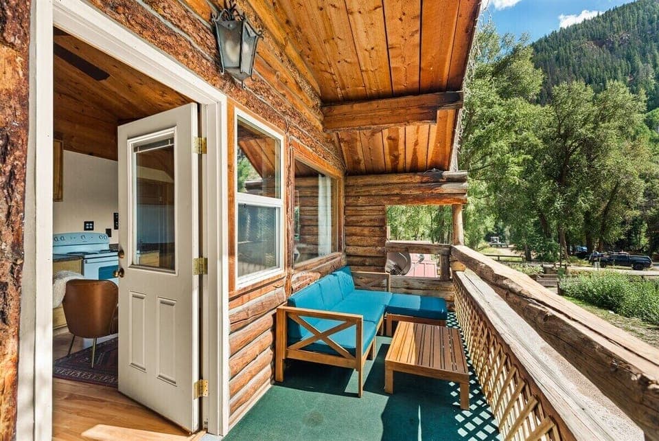 Your cozy porch with views looking out at the Maroon Bells and Willow Creek running by your apartment.