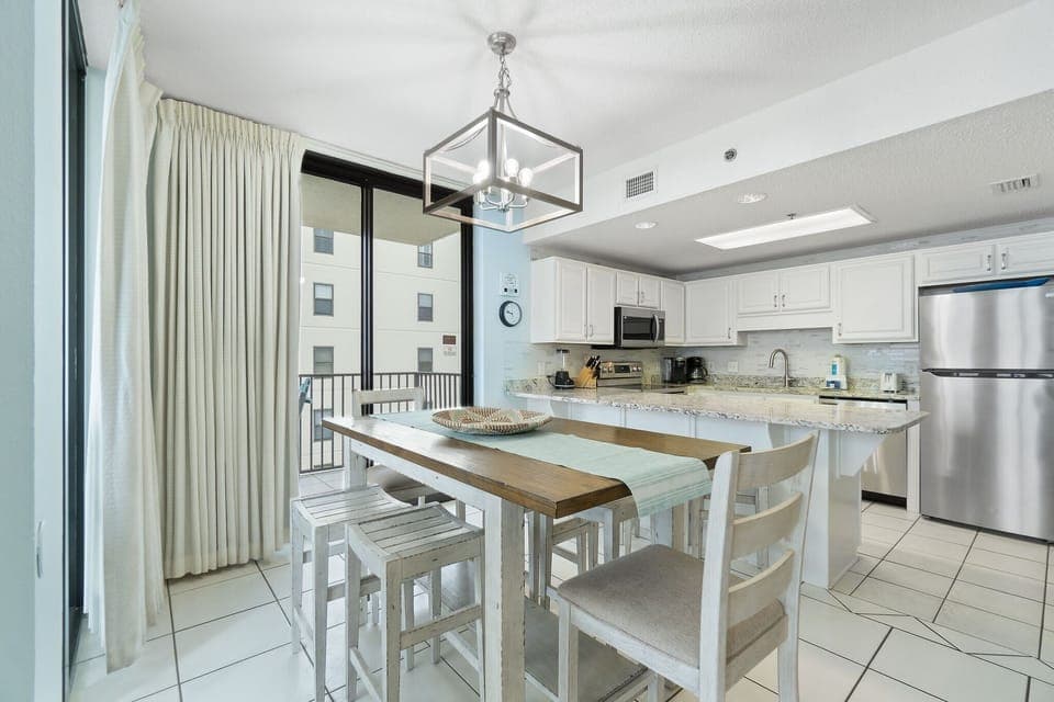 Dining table comfortably seats six with additional seating at kitchen bar.