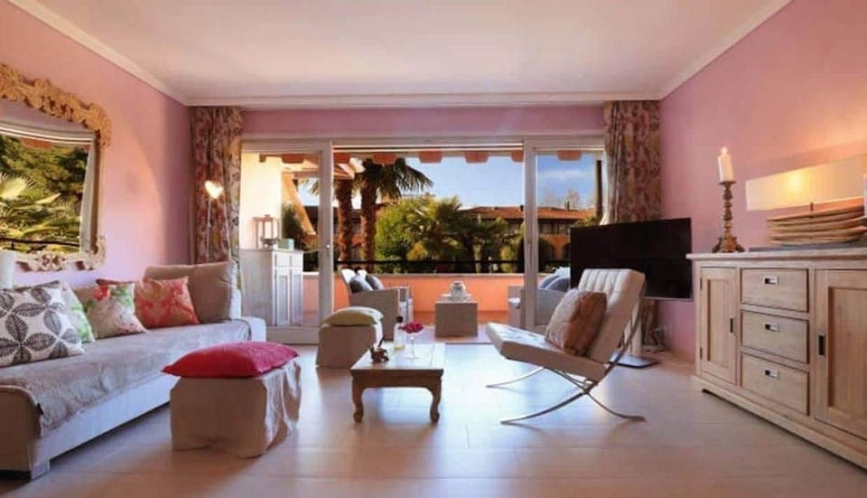 View of the living room and the balcony-terrace surrounded by greenery. 