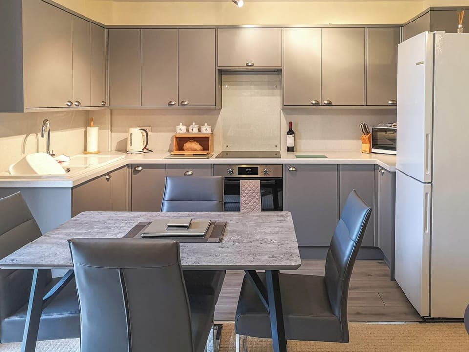 Kitchen/diner with bottle of wine and homemade bread | Cysgod Y Coed, Llanbedr