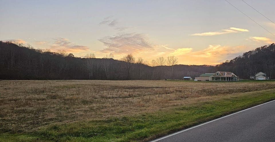 Sunset view of  the Hocking Hills Copper House and meadow.
