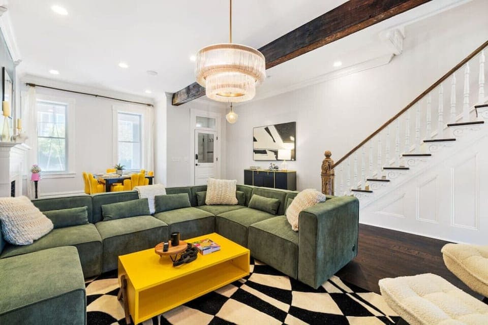 An inviting living room with a spacious couch, elegant foyer, and a dazzling chandelier, creating a perfect blend of comfort and sophistication.