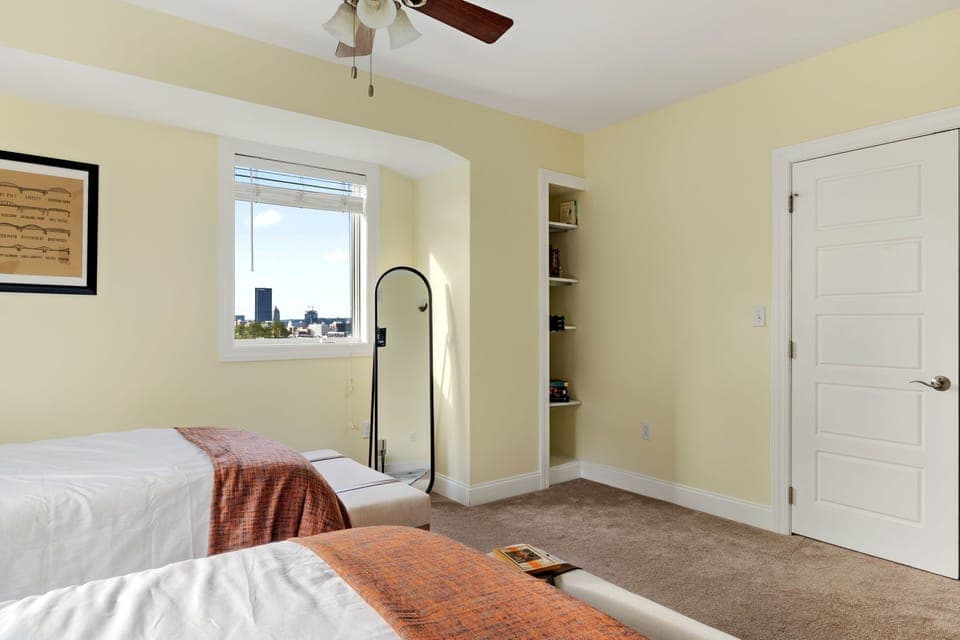 A bedroom equipped with a mirror and a storage rack