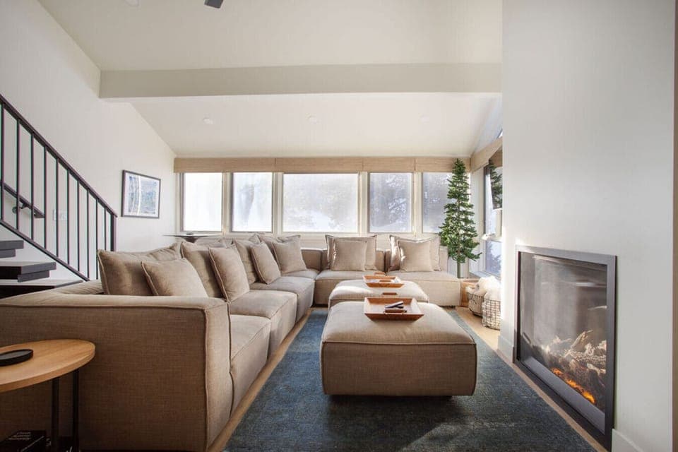 Oversized Living Room couch with fireplace and views of mountain and lift