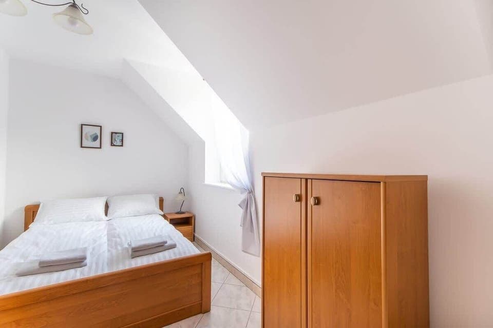 A wider view of the bedroom, showcasing its simplicity and ample space.

