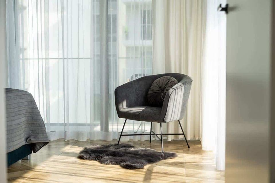 A sunny corner by the floor-to-ceiling window with an armchair, perfect for reading or relaxation.
