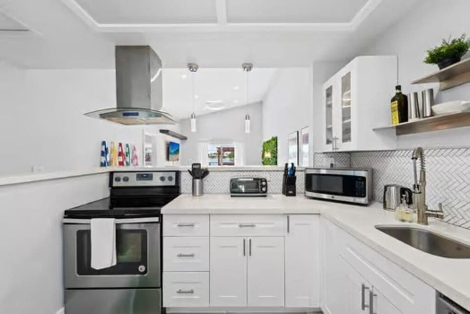 This fully equipped kitchen boasts sleek base cabinets and a modern range hood