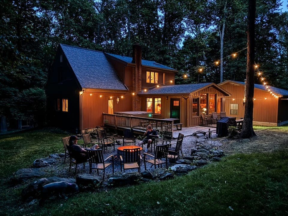 Unwind beneath the string lights in your own secluded backyard—complete with a hot tub, fire pit, and nothing but forest around you.
